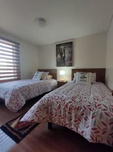 a bedroom with two beds and a window at Garcia hurtado departamento diario in Osorno