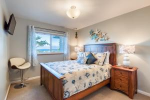 a bedroom with a bed and a window and a chair at Pacific Peek One - OceanView - EV Charger - Pet OK in Wecoma Beach