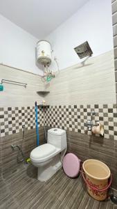 a bathroom with a toilet in a room at Khaleel Manzil Luxe Stays in Hyderabad