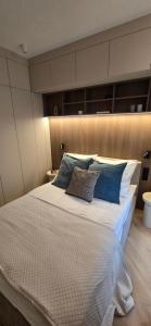 Un dormitorio con una cama grande con dos almohadas encima. en Vilda Moderne, en Poznan