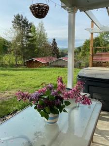 un vaso di fiori viola seduto su un tavolo di Paradise Eastern Township cottage a Cowansville