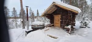 a log cabin with snow on the roof at Ukonloma Aimola in Rovaniemi +1 photo