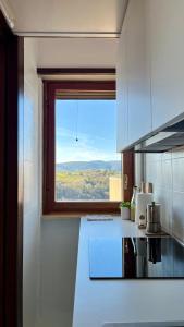 cocina con ventana grande y encimera blanca en La Coppetta di CrisandSimo, en Perugia
