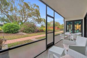 a balcony with a table and chairs and windows at First Floor Deluxe Condo -Updated and Chic in Naples