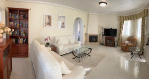 a living room with a white couch and a tv at Casa Sara - Private Villa with Private Pool in Ciudad Quesada