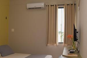 a bedroom with a bed and a window with curtains at Hotel Pousada Do Lago in Campo Maior