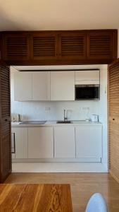 Una cocina con gabinetes blancos y un microondas. en La Coppetta di CrisandSimo, en Perugia