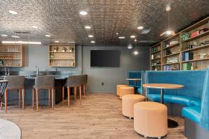 a bar with tables and chairs and a tv at My Sweet Rentals- 30 night min in Aurora