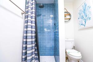 a bathroom with a blue shower curtain and a toilet at NEW5 LUXURYSTUDIO Nr DISNEY PETSOKprivENTRY in Kissimmee +17 photos