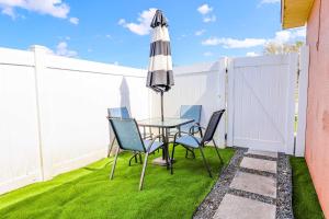 a table and chairs with an umbrella on a lawn at NEW5 LUXURYSTUDIO Nr DISNEY PETSOKprivENTRY in Kissimmee