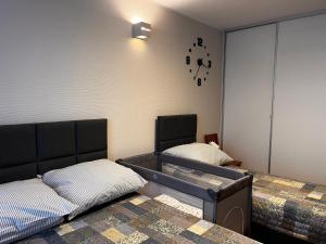 a bedroom with two beds and a clock on the wall at Apartament Panorama Starego Miasta in Lublin