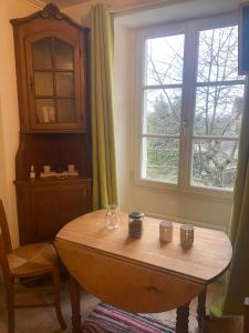 a room with a wooden table and a window at Studio pour 1 personne au cœur du Perche in Rémalard en Perche