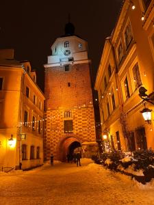a building with a clock tower at night at Apartament Panorama Starego Miasta in Lublin