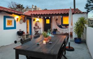 a wooden table in front of a house at Refúgio da Alma in Mafra
