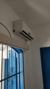 Habitación con ventilador de techo y ventana. en Farol da Praia Hostel, en Cabo Frío