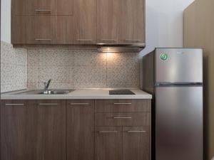Una cocina con gabinetes de madera y un refrigerador de acero inoxidable. en Luxury Living Annio, en Nikiti 17 fotos más