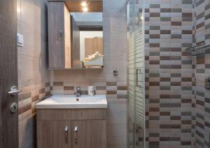 un baño con lavabo y espejo en Luxury Living Annio, en Nikiti