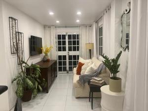 a living room with a couch and some plants at Moulin A Vent Apartment in Monchy