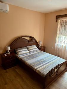 a bedroom with a bed with a wooden headboard and a window at Villa Piste - Skadar Lake in Virpazar +35 photos