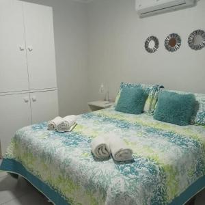 Un dormitorio con una cama con toallas. en El Colibrí, en Villa Elisa