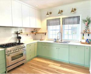 a kitchen with white cabinets and a stove top oven at The Big Twisted Oaks in Bay Saint Louis