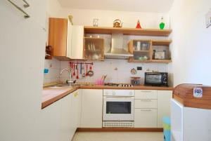 a kitchen with white cabinets and a stove top oven at Chiara House in Monticiano +3 photos