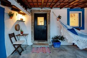a room with a black door and a table and a chair at Refúgio da Alma in Mafra