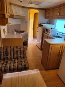 a small kitchen with a stove and a couch at Sítio da Cornucópia Home Mobile in Moncarapacho