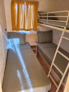 a room with two bunk beds and a couch at Sítio da Cornucópia Home Mobile in Moncarapacho