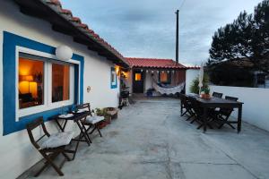 a patio with a table and chairs next to a house at Refúgio da Alma in Mafra