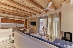 a living room with a couch and a table at Aegean Sunset Villas & Spa 'Villa Sky' in Skouloúfia