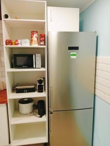 lodówka ze stali nierdzewnej z kuchenką mikrofalową w kuchni w obiekcie Habitaciones Casa Santander Playa Valdenoja w mieście Santander