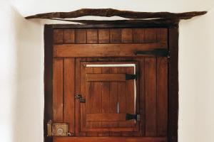 a wooden door in the corner of a room at Refúgio da Alma in Mafra