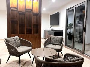 a living room with two chairs and a table at Condo Playa & Waterfront Heated Alberca in Mazatlán