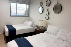 a bedroom with two beds and a window at Condo Playa & Waterfront Heated Alberca in Mazatlán +19 photos