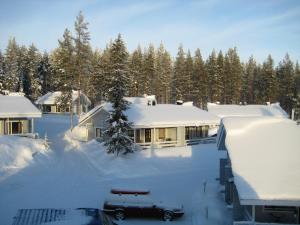 um quintal coberto de neve ao lado de uma casa em Kuerkaltio Holiday Village em Äkäslompolo