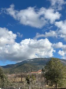 a blue sky with white clouds over a mountain at Casa Rural Los Laureles in Venta del Baúl