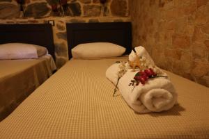 a room with two beds with towels on them at STONE of KAMARIZA in Áyios Konstandínos