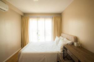 a bedroom with a white bed and a window at Casa - Coastal Getaway Two-Bedroom Vacation Home with free parking in Amalfi by City de Mare in Cebu City