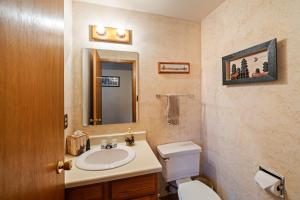 a bathroom with a sink and a toilet and a mirror at Cozy Ski-In Ski-Out Big Mountain Condo in Whitefish
