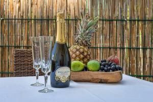 una botella de champán y dos copas en una mesa con fruta en Heavenly Dream House With Pool, en Stanići