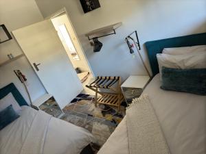 a bedroom with two beds and a chair and a mirror at Faulaa Apartment in Cape Town