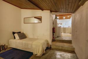 a bedroom with a bed and a bathroom at Refúgio da Alma in Mafra