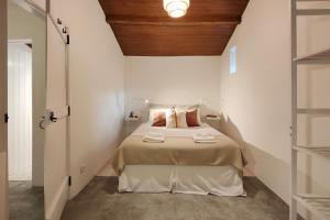 a bedroom with a bed with a wooden ceiling at Refúgio da Alma in Mafra