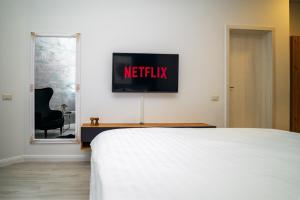 ein Schlafzimmer mit einem Bett und einem Fernseher an der Wand in der Unterkunft Escape Studio Pollux Militari in Dudu