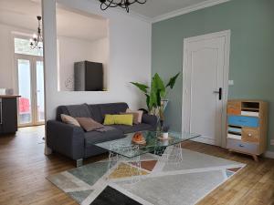 a living room with a couch and a glass table at MARCELINE in Lannion
