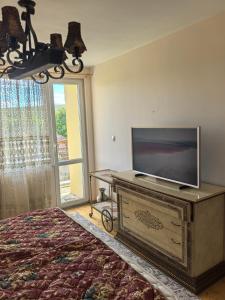 a bedroom with a tv on top of a bed at Вила Езерото in Lipnik