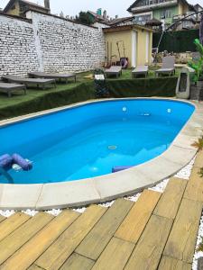 a large blue swimming pool with a wooden deck at Вила Езерото in Lipnik