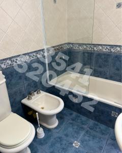 a bathroom with a toilet and a sink and a tub at Casa Chalet Carlos Paz in Villa Carlos Paz +7 photos