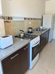 a kitchen with a stove with pots and pans on it at Alojamiento Puerto Madryn a metros del Mar in Puerto Madryn
